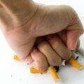 Fist crashing cigarettes for quit smoking concept